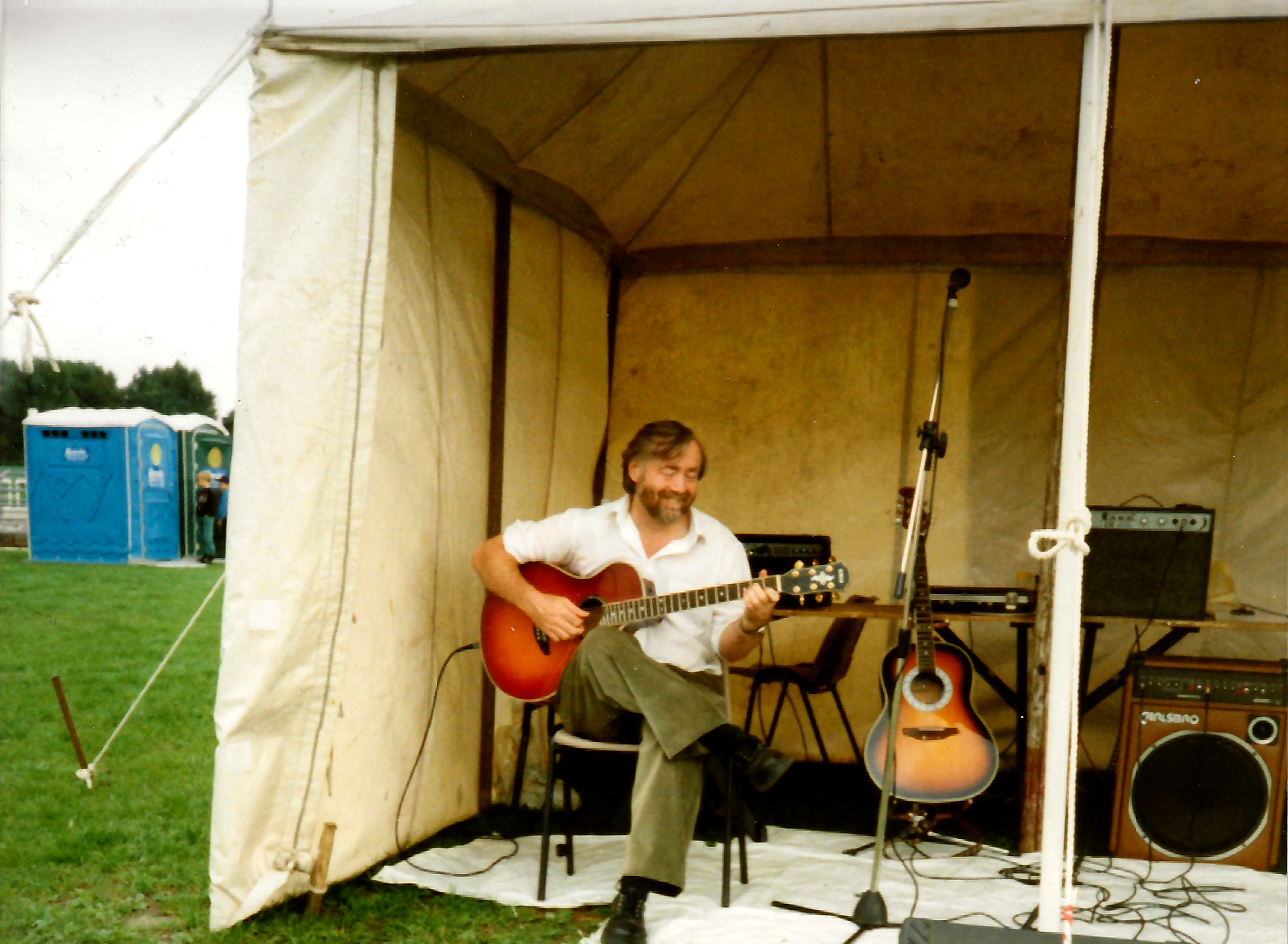 Steve McWilliam playing acoustic guitar solo in the Nobody's Business performance tent at Spike Island in 1995