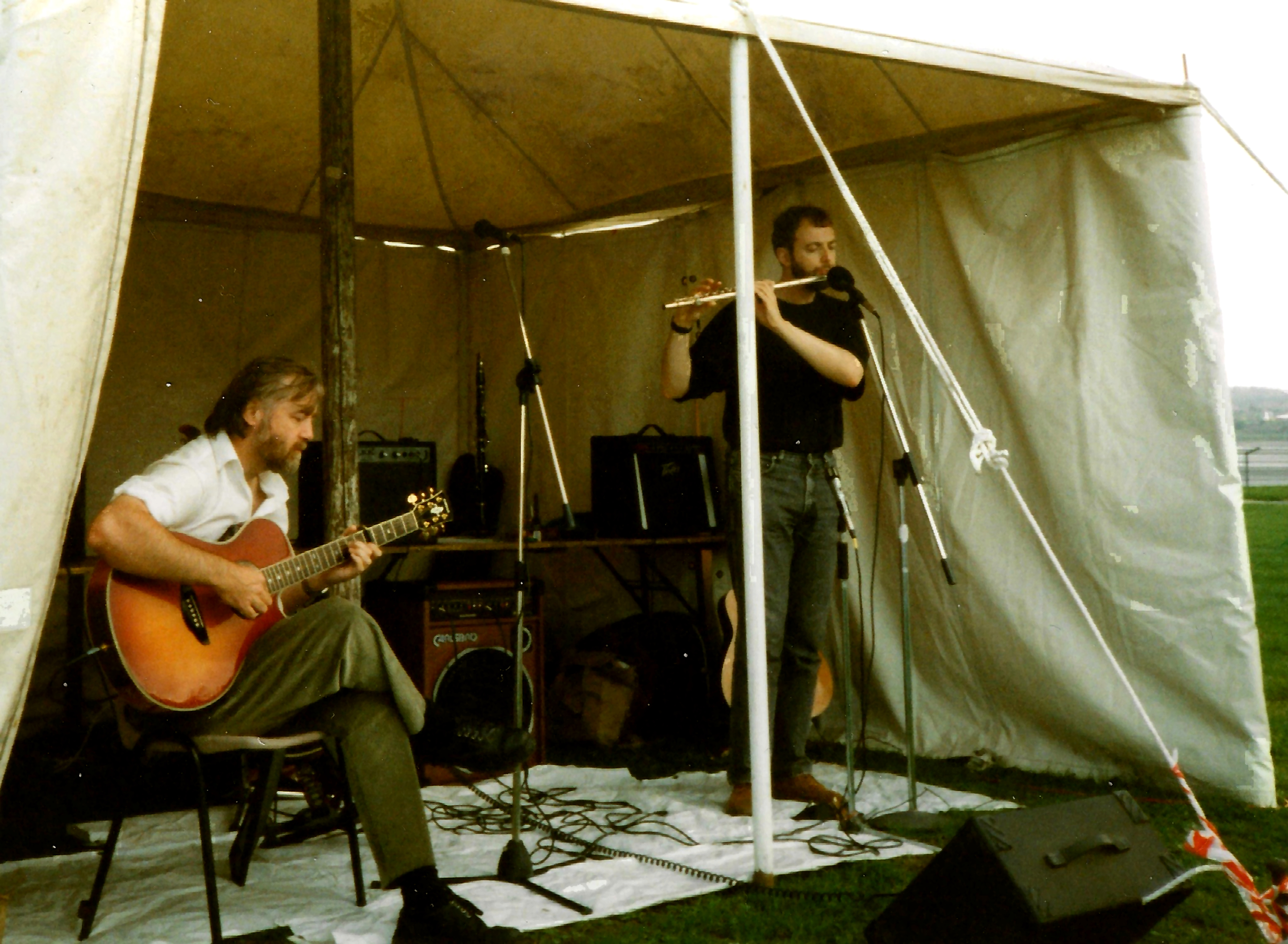Steve McWilliam playing acoustic guitar while Ian Jesse plays flute at Spike Island in 1995