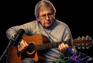 Patrick Collard playing acoustic guitar in a recording session